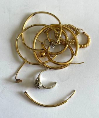 un tas de bijoux en or posé sur une surface blanche