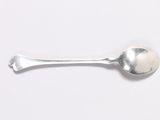 a silver spoon with a spoon handle on a white surface