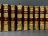 several old books are lined up in a row on a table