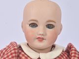 a small doll with a red and white checkered dress