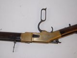 a close up of a rifle on a white surface with a hook