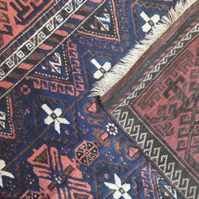 a close up of a blue and red rug with a pattern on it