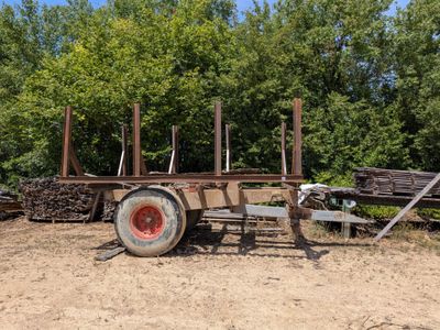 un tracteur garé à côté d'un tas de bois