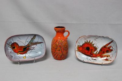 trois assiettes et un vase posés sur une table