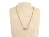 a gold necklace with a pearl on a mannequin neck