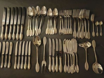 a lot of spoons and forks laid out on a table