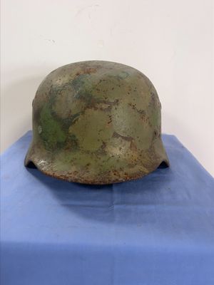an old helmet on a blue cloth on top of a blue table