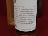 une bouteille de vin posée sur une table à côté d'un verre