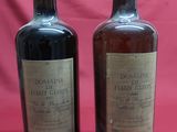 two bottles of wine sitting on top of a red cloth