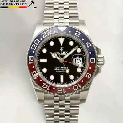 a close up of a wrist watch with a red and blue bezel