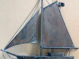 a metal model of a sailboat hanging on a wall