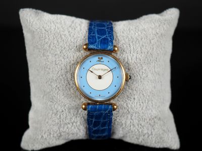 un gros plan d'une montre-bracelet posée sur un oreiller