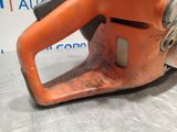 an orange chainsaw sitting on top of a metal table