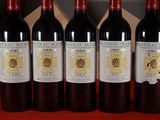 six bottles of wine are lined up on a table
