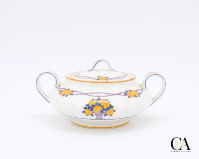 une théière blanche ornée d'un motif jaune et bleu