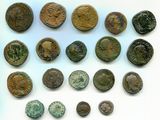 Un assortiment de pièces de monnaie romaines antiques est présenté sur un support blanc
