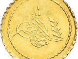 Gros plan sur une pièce d'or portant une écriture arabe