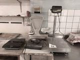 une photo d'une cuisine avec une balance et un ordinateur portable posés sur le plan de travail