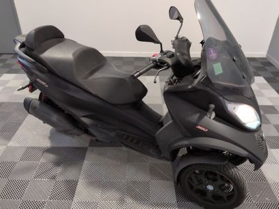 un scooter garé sur un sol à damier