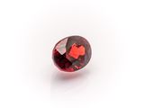 a close up of a red diamond on a white surface