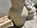 a large vase sitting on a stand next to a buddha statue
