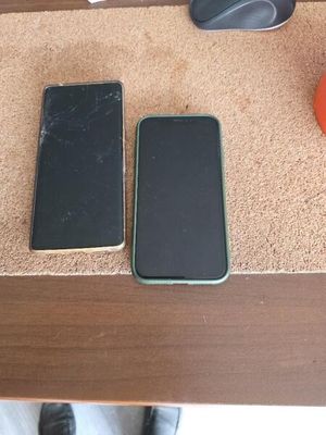 trois téléphones portables posés sur une table à côté d'une souris d'ordinateur