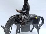 une statue représentant un homme assis sur un cheval, tenant un livre