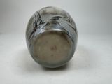 a black and white vase sitting on a white surface