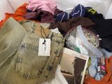 a pile of clothes and a book on a bed