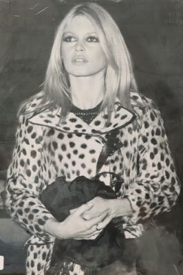 photographie en noir et blanc d'une femme vêtue d'un manteau à pois tenant un ours en peluche