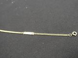 gros plan d'un bracelet en or sur une surface noire