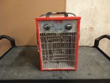 a small red heater sitting on top of a table