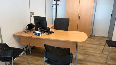 un bureau avec deux chaises et un ordinateur dessus
