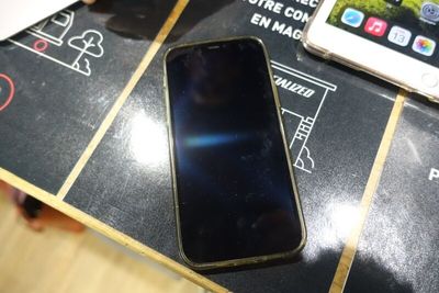 un téléphone portable posé sur une table, à côté d'autres objets