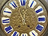 a gold clock with blue and white decorations on it