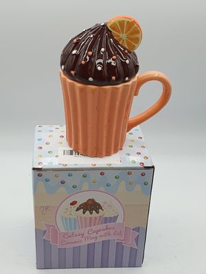 un cupcake posé sur une boîte, surmonté d'une tranche d'orange