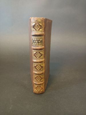 a small vase with a book on it sitting on a table