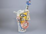 a ceramic sculpture of a bird with a face on it ' s head