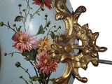 a blue vase with flowers painted on it and a gold handle