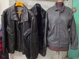 trois vestes en cuir accrochées au mur à côté d'un mannequin