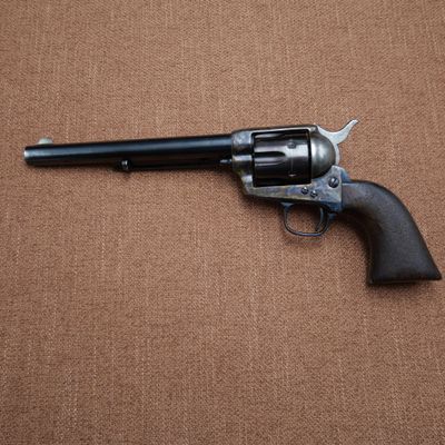 a gun that is laying on the ground with a brown background