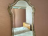 un miroir accroché au mur au-dessus d'un lit