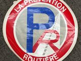 un panneau rouge et blanc sur lequel on peut lire « La prévention routière »