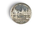 a silver coin with a picture of a city on it