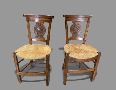 two wooden chairs with a wicker seat on them