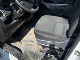 the interior of a white van with the door open and the driver ' s seat down