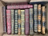 de nombreux livres anciens dans une boîte en carton posée sur l'étagère