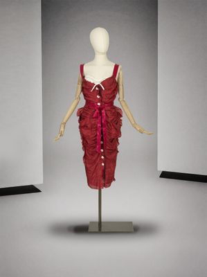 mannequin en robe rouge, posé sur un socle dans une pièce