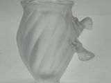 a glass vase with a bird on it on a white surface