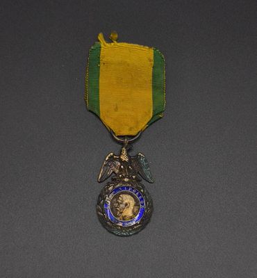 an image of a medal with a ribbon around it on a gray surface